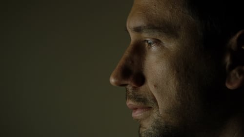 Man's Thoughtful Face Profile in Warm Light