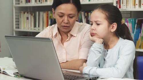 Girl Studies with an Adult in the Library