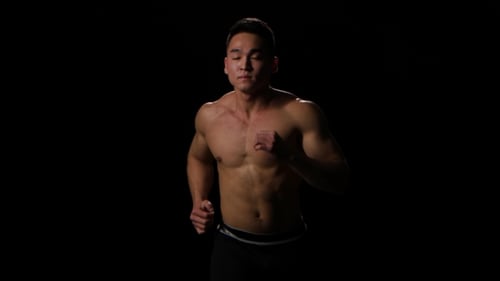 Shirtless Muscular Man Running in Place in the Dark