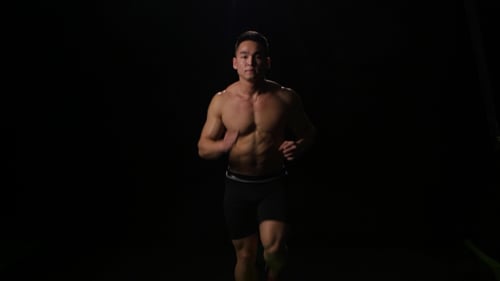 Sportsman Running on the Black Background at Fast Pace. Studio
