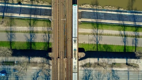 Personenzug fährt auf der Eisenbahnbrücke über den Fluss und die Autobahn