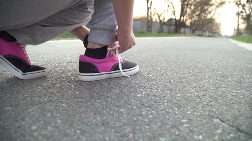 Person Tying Shoe Laces Before Road Run
