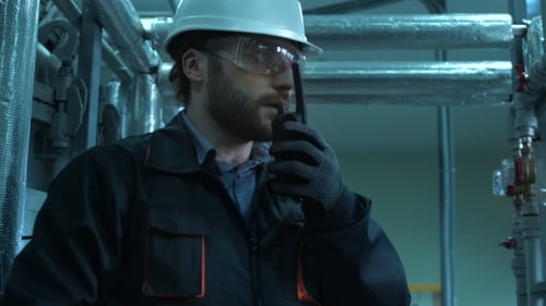 Techniker inspiziert Rohre und meldet sich an das Funkgerät