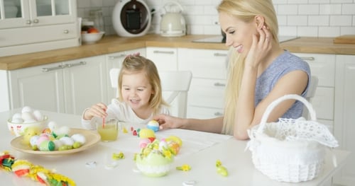 Laughing Woman and Little Girl Coloring Eggs