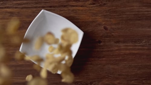 Corn Flakes Falling in White Bowl