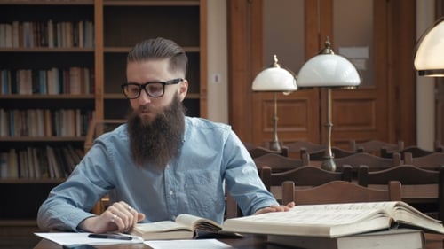 Student Preparing Exam and Learning Lessons in School Library