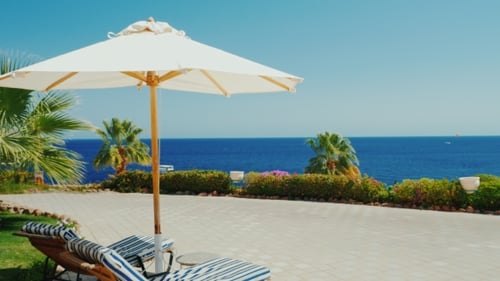 Ein Ort des Paradieses: Ruhe, Sonnenschirm und blaues Meer an einem sonnigen Tag