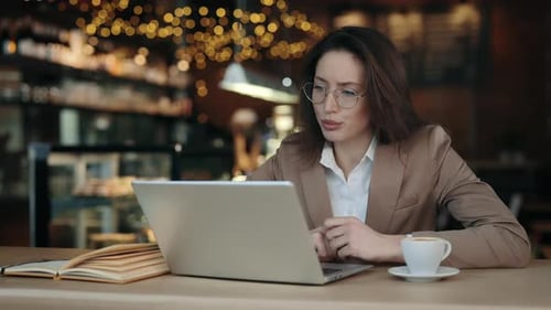Businesswoman Attending Virtual Meeting at Cafe