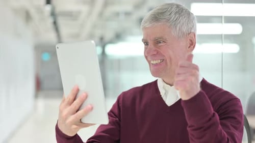 Middle Aged Man Celebrating Success on Tablet