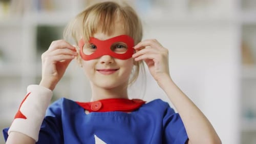 Blonde Girl in Superhero Costume Puts on Mask
