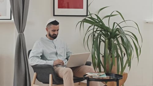 Man Uses Laptop in Bright Modern Room