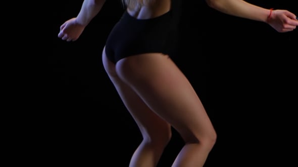 Woman Dancing in Black Bodysuit on Black Background Woman Dancing in Black Bodysuit on Black Background