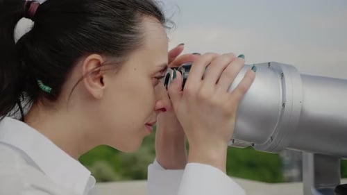 Close Up of Young Woman Using Binoculars for Sightseeing