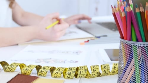 Fashion Designer Sketching Dress with Colored Pencils