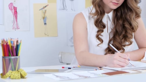 Fashion Designer Drawing Sketches at Her Desk