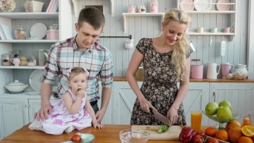 Happy Young Family Cooking in Kitchen at Home, Vegetables Salad and Fruits, Healthy Breakfast