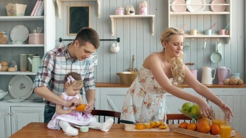 Family Preparing Fresh Orange Juice in Kitchen