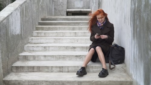 Young Woman Using Mobile Phone on Concrete Steps