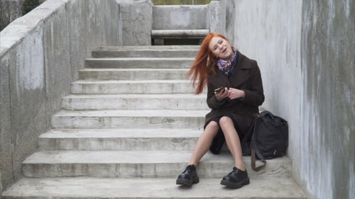 Woman Using Phone on Concrete Urban Staircase