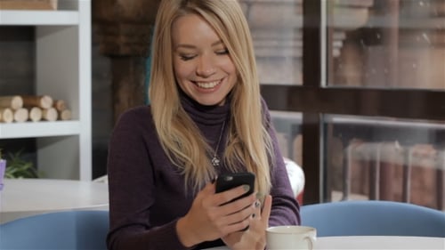 Girl Uses Her Smartphone at the Cafe