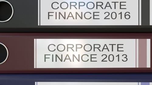 Vertical Stack of Multicolor Office Binders with Corporate Finance Tags Different Years