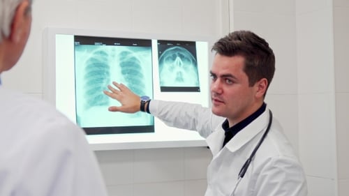Doctors Discussing X-Ray in Bright Medical Room