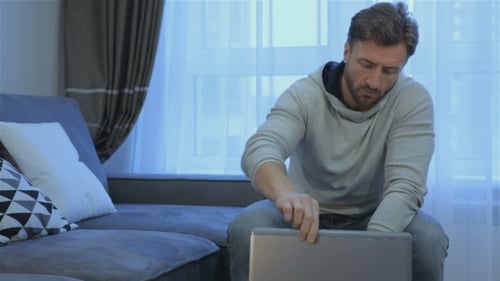 Man Opens Laptop at Home