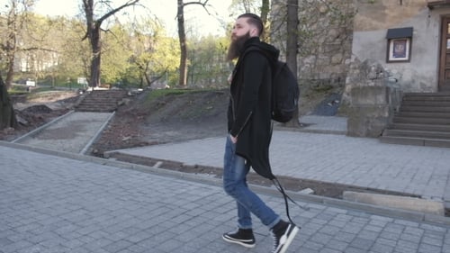 Young Attractive Cheerful Man with Dark Hair with a Beard Wearing a Shirt and a Black Jacket