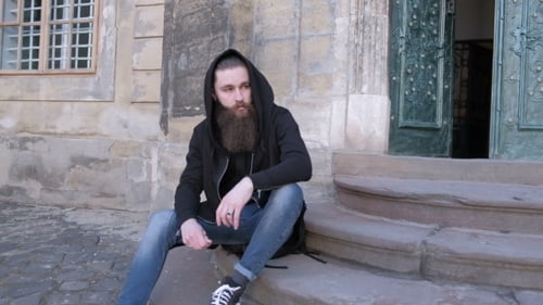 Man with Beard Sitting on Old Building Steps