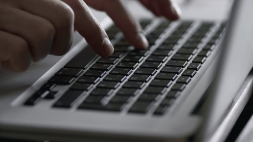 Silhouette of Hands on Keyboard of Modern Laptop. Fingers Typing Text.