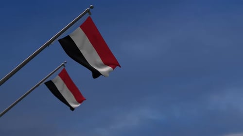 Realistic Yemen National Flags Waving in Wind Against Blue Sky