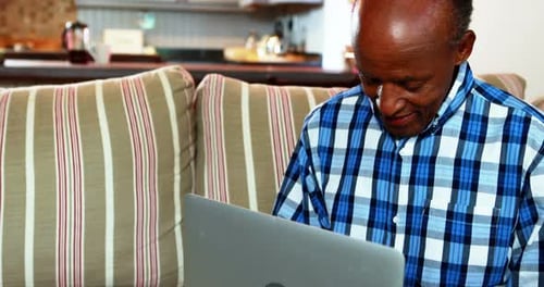 Senior Adult Using Laptop Computer at Home