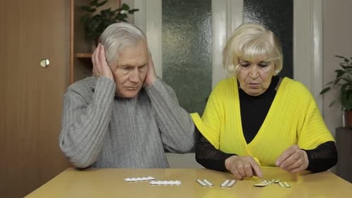 Elderly Couple Managing Medications at Home Indoors