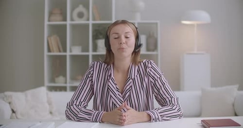 Woman Chatting Online with Headset at Desk