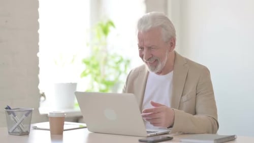 Old Man Talking on Video Call on Laptop in Office