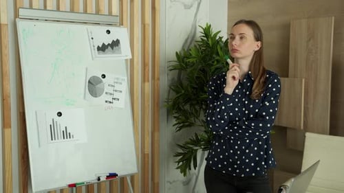 Thoughtful Woman Sketching Out a Business Plan in a Creative Office