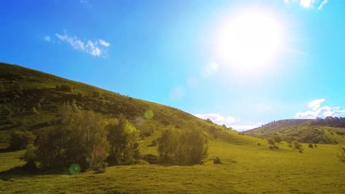 UHD Mountain Meadow Timelapse at the Summer. Clouds, Trees, Green Grass and Sun Rays Movement