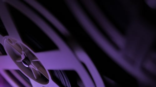 Rotating Film Reel Under Purple Lighting