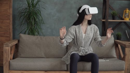Woman Experiences Virtual Reality at Home on Couch
