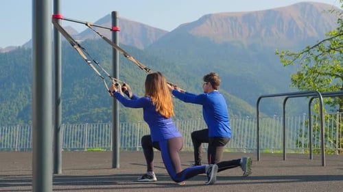 Couple s'entraînant ensemble à l'aide de sangles Trx