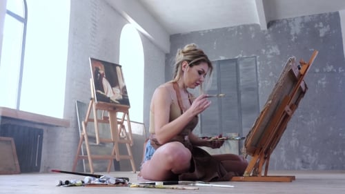 Female Artist Painting Picture in Studio Sitting on the Floor