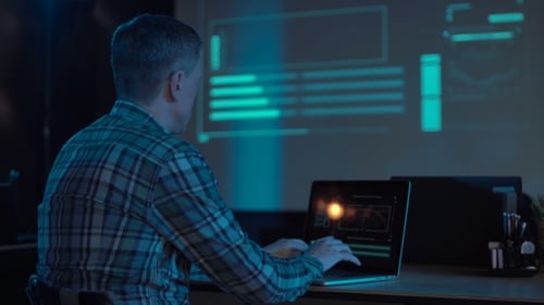 Mann arbeitet nachts mit Laptop