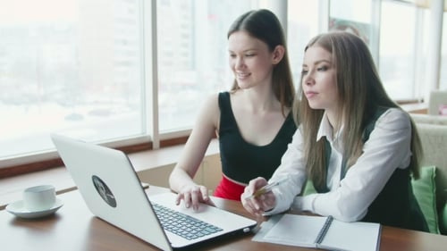 Dos mujeres de negocios hablan sobre el trabajo en un café