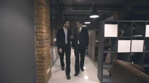 Men in Suits Walking and Talking in Office
