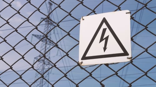 Subestación eléctrica. Señal de advertencia sobre el riesgo de descarga eléctrica. Cables de alta tensión en el soporte