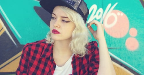Stylish Young Woman Posing in Front of Graffiti