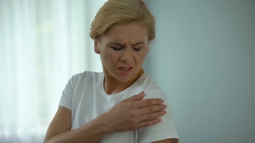 Woman Rubbing Shoulder Due to Painful Injury
