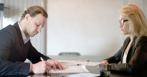 Business Professionals Signing Agreement in Modern Office