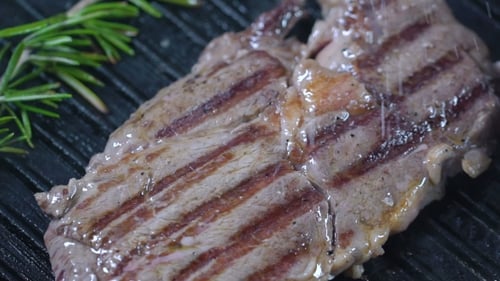 Beef Steak on the Grill Sprinkled with Salt