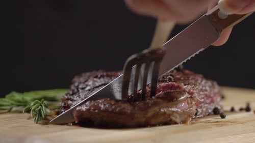 Slicing Medium Rare Steak on Cutting Board